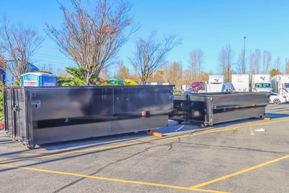 Professional dumpster rental service with roll-off container on residential driveway in Dracut